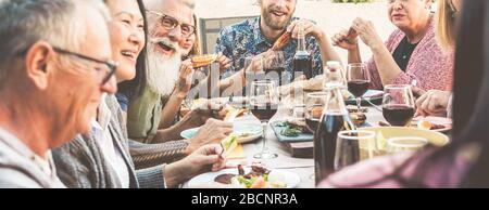 Glückliche Familienmitglieder, die Spaß am Grillabendessen haben - Multirassische Freunde, die beim grillessen essen essen - Essen, Freundschaft, Beziehung und Sommerlebensstilkonce Stockfoto