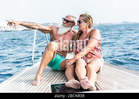 Älteres Paar auf dem segelboot während eines luxuriösen Urlaubs auf dem Meer - alte trendige Leute, die Spaß am exklusiven Urlaub haben - Reisen und fröhliches älteres Konzept - Stockfoto