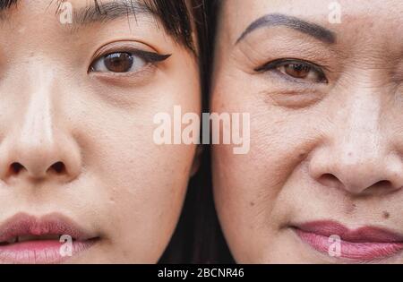 Echte Menschen asiatische Mutter und Tochter vor der Kamera - nicht retuschierte Gesichter - konzentrieren sich auf das Auge des Mädchens Stockfoto