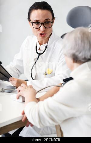 Gesundheitsversorgung im Krankenhauskonzept. Ärztin berät alte Dame Stockfoto