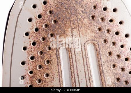 Verbrannte Eisenunterseite, Makro Hintergrundtextur, Nahaufnahme. Beschädigtes, verbranntes Bügeleisen, flatiron Metall aus nächster Nähe, Bügelprobleme, Reinigung. Hausgebrauch, Haus Stockfoto