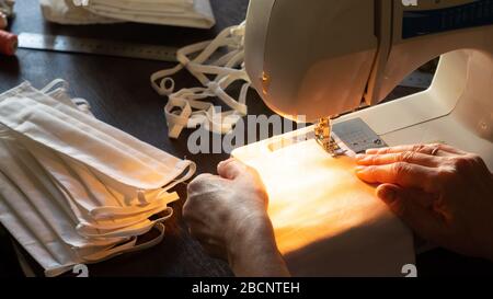 Antivirus Schutzmasken zu Hause nähen. Frau näht Masken auf einer Nähmaschine Stockfoto