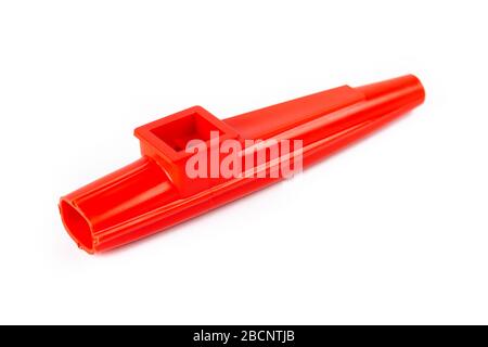 Rotes Kazoo, traditionelles Musikinstrumenten-Objekt aus Kunststoff isoliert auf weiß, herausgeschnitten, Nahaufnahme. Kinder einzigartige Blasinstrumente mit vibrierender Membran Stockfoto