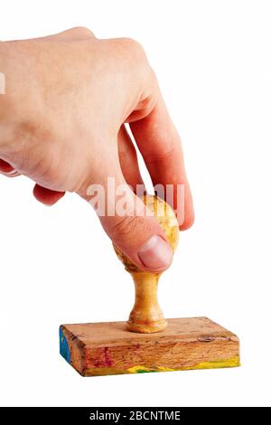 Einfache Handstempel-Geste, alter traditioneller Holzstempel in der Hand isoliert auf Weiß, herausgeschnitten. Drücken des Stempels gegen das Papier Stockfoto