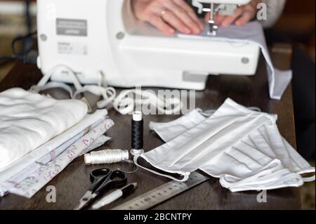 Antivirus Schutzmasken zu Hause nähen. Frau näht Masken auf einer Nähmaschine Stockfoto