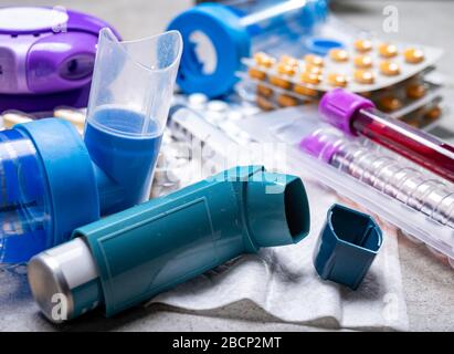 Verschiedene Medikamente für Asthmabedrohungen, Pillen, Inhalatoren, Blutteströhrchen und Spritzen, Krankenhaushintergrund aus nächster Nähe Stockfoto