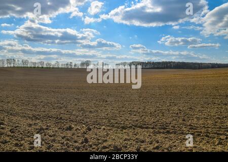 Lietzen, Deutschland. April 2020. Wolken ziehen über ein frisch gepflüpftes Feld. Credit: Patrick Pleul / dpa-Zentralbild / ZB / dpa / Alamy Live News Stockfoto