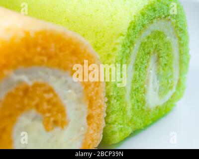 Texturdetails auf der Oberfläche von cremefarbenem und orangefarbenem Rollkuchen Stockfoto