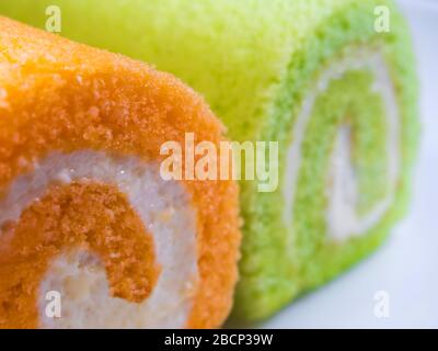 Texturdetails auf der Oberfläche von cremefarbenem und orangefarbenem Rollkuchen Stockfoto