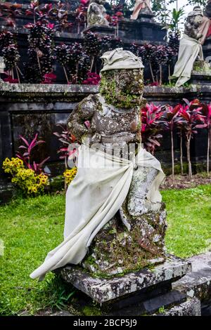 Eine Skulptur einer in Sarong und Udeng gekleideten, mythologischen Kreatur im Pura Besakih-Tempel, Bali, Indonesien Stockfoto