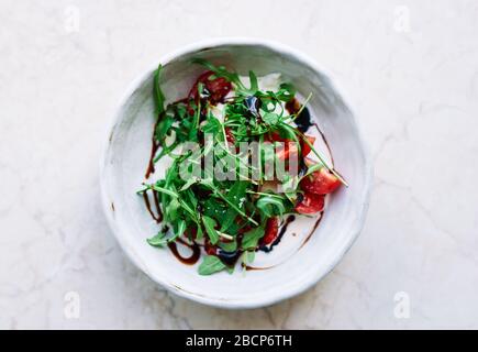 Hausgemachter Vitaminsalat mit Rucola, Kirschtomaten und Mozzarella-Käse Draufsicht Stockfoto