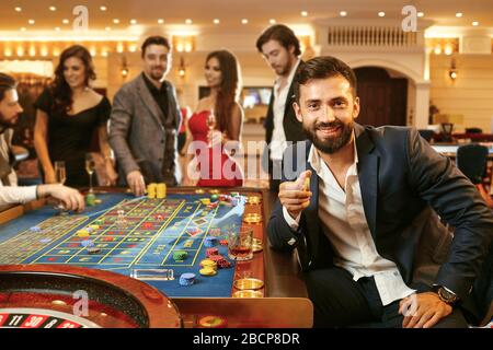 Ein Mann mit Chips in der Hand, der Poker bei einem Casino-Poker-Roulette spielt. Stockfoto