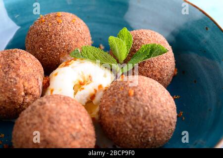 Tiramisu aromatisierte Schokoladentrüffel Pralinen süße Mini-Imbiss-Kugeln auf einem blauen Plattenhintergrund Stockfoto