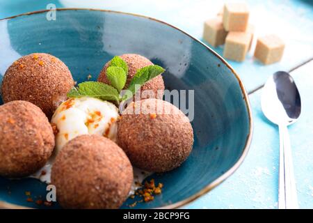 Tiramisu aromatisierte Schokoladentrüffel Pralinen süße Mini-Imbiss-Kugeln auf einem blauen Plattenhintergrund Stockfoto