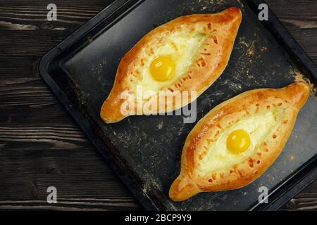 Khachapuri in Adjarian. Offene Pastete mit Mozzarella und Ei. Kaukasische Küche. Backwaren. Draufsicht. Stockfoto