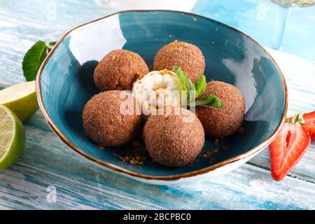 Tiramisu aromatisierte Schokoladentrüffel Pralinen süße Mini-Imbiss-Kugeln auf einem blauen Plattenhintergrund Stockfoto