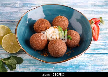 Tiramisu aromatisierte Schokoladentrüffel Pralinen süße Mini-Imbiss-Kugeln auf einem blauen Plattenhintergrund Stockfoto