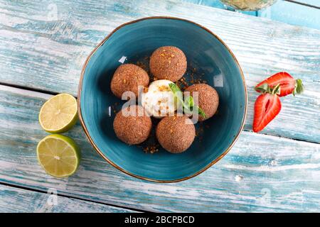 Tiramisu aromatisierte Schokoladentrüffel Pralinen süße Mini-Imbiss-Kugeln auf einem blauen Plattenhintergrund Stockfoto