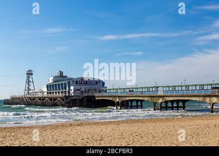 Bournemouth, Dorset UK. April 2020. Wetter in Großbritannien: Sonniger Tag, an dem die Menschen am Meer ihre tägliche Bewegung Unternehmen, am meisten unter Einhaltung der Einschränkungen von Coronavirus für soziale Distanzierungen. Bleib in der Nachricht zu Hause auf dem Steg, der geschlossen ist. Credit: Carolyn Jenkins/Alamy Live News Stockfoto