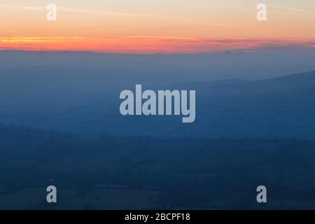 Leuchtend rote Wolken über den sanften Hügeln britischer Landfelder im Susnet Stockfoto