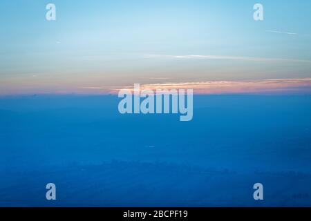 Duftig-dämmerischer Himmel über der malerischen Landschaft in Blautönen. Stockfoto