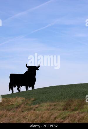 Bulle Spanischer Toro de Osborne schwarzer Bulle, traditionell auf einem Hügel. Inoffizielles Symbol von Spanien. Geschützte Brandy Anzeige Symbol.Wahrzeichen. Hochformat. Stockfoto