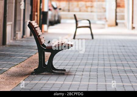 Leere Bänke auf einer Straße. Keine Menschen, Begriff der Einsamkeit. Stockfoto
