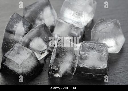 Viele Eiswürfel auf schwarzem Hintergrund. Das Konzept der kalten Getränke. Stockfoto