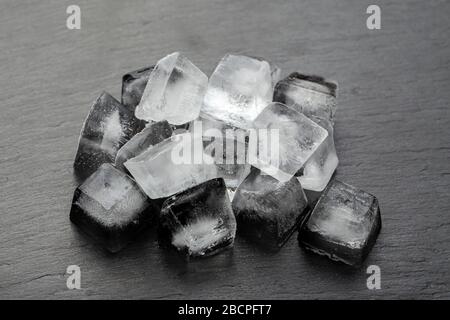 Viele Eiswürfel auf schwarzem Hintergrund. Das Konzept der kalten Getränke. Stockfoto