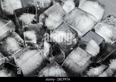 Viele Eiswürfel auf schwarzem Hintergrund. Das Konzept der kalten Getränke. Stockfoto