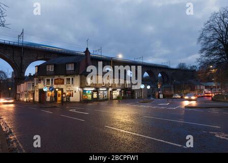 Erster TransPennine Express Zug mit Bewegungsunschärfe überquert den gewölbten Durham Viadukt an der Ostküste bei Dämmerung am Brückenhotel vorbei Stockfoto