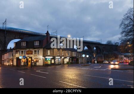 Erster TransPennine Express Zug mit Bewegungsunschärfe überquert den gewölbten Durham Viadukt an der Ostküste bei Dämmerung am Brückenhotel vorbei Stockfoto