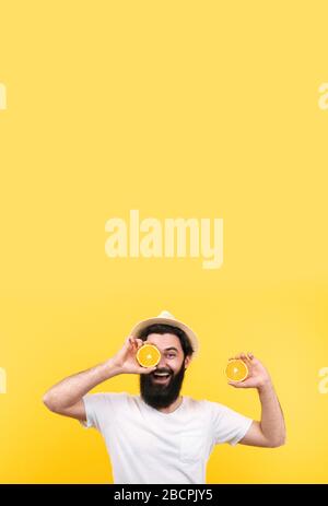 Fröhlicher Sommermann in panamahut mit Orangenfrucht, verspottes Bild mit Platz für Text Stockfoto