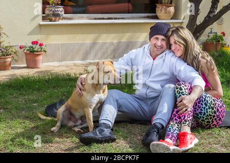 Ein Paar, das mit Hund im House-Yard spielt Stockfoto