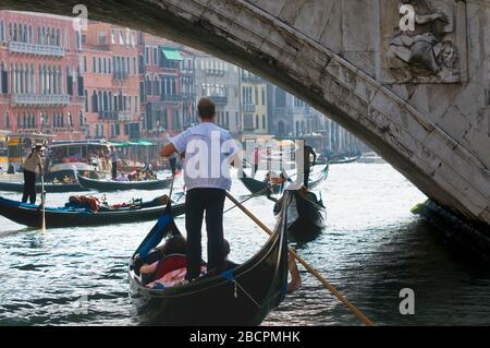 Gondeln mit Touristen unter der Rialto-Brücke, im Touristenzentrum der Stadt Venedig Italien. Reise- und Urlaubskonzept. Stockfoto