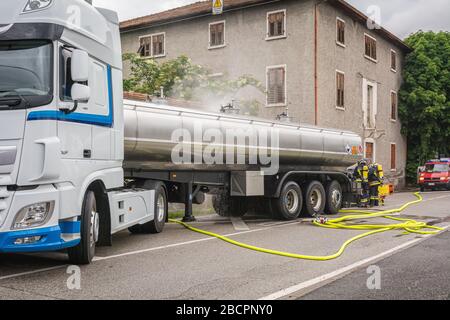 Feuerwehrmann bei einer Simulation von Verkehrsunfällen mit Autos, Zügen und Lastwagen. Feuerwehrleute mit eigener Atemschutzausrüstung und Schutzeinrichtung Stockfoto