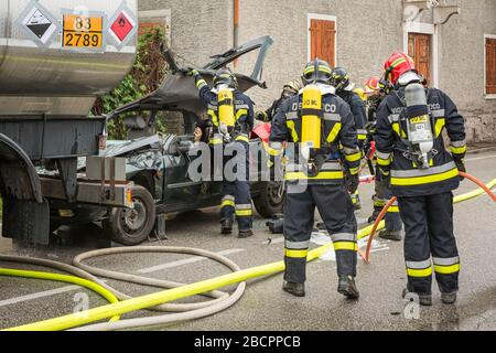 Feuerwehrleute retten eingeklemmten Fahrer während einer Unfallsimulation mit Autos, Zug und Lastwagen. Feuerwehrleute mit Atemschutzgerät und Hyd Stockfoto