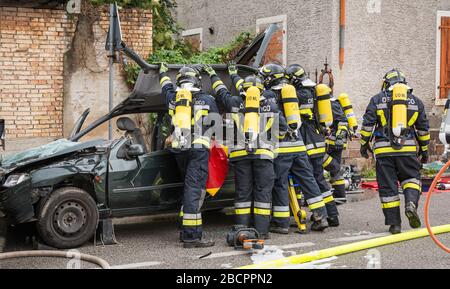 Feuerwehrleute retten eingeklemmten Fahrer während einer Unfallsimulation mit Autos, Zug und Lastwagen. Feuerwehrleute mit Atemschutzgerät und Hyd Stockfoto