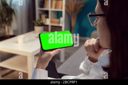 Brunette mit horizontalem Handy Stockfoto