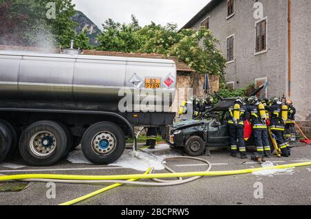 Feuerwehrleute retten eingeklemmten Fahrer während einer Unfallsimulation mit Autos, Zug und Lastwagen. Feuerwehrleute mit Atemschutzgerät und Hyd Stockfoto