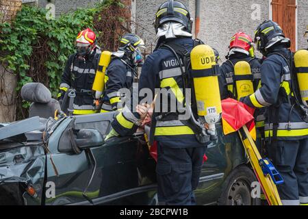 Feuerwehrleute retten eingeklemmten Fahrer während einer Unfallsimulation mit Autos, Zug und Lastwagen. Feuerwehrleute mit Atemschutzgerät und Hyd Stockfoto