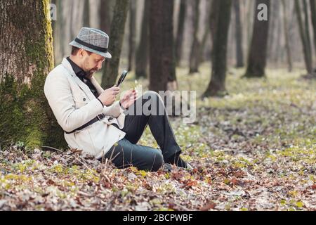 Mann mit Blick auf Blume, Lupe Stockfoto