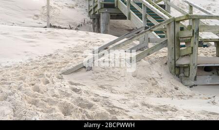 Holztreppen am Strand sind mit Sand durchgeblasen Stockfoto