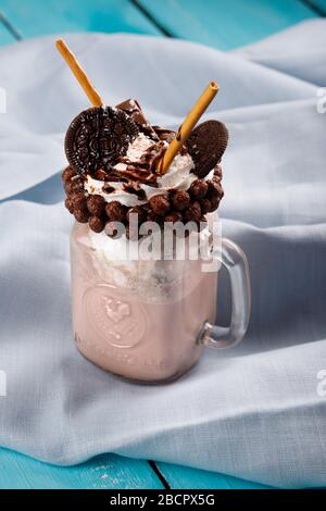 Karamell und Schokolade verwöhnen extreme Milchshakes mit Schokoladenkuchen, Plätzchen, Marshmallows und Süßigkeiten. Verrückte Tendenz zum Verwackeln von Lebensmitteln. Stockfoto