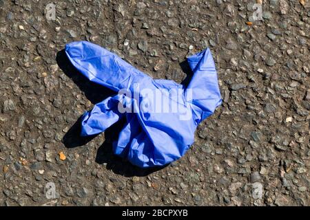 Gesundheitlicher Schutzhandschuh/Handschuhe aus Latex oder Vinyl, die als Abfall auf der Straße entsorgt wurden, vermutlich von einer Person, die sich Sorgen um das Coronavirus COVID-19 macht. Das fallen dieser Handschuhe ist ein neues Phänomen und ist ziemlich weit verbreitet. Twickenham. GROSSBRITANNIEN. Einzelne Handschuhe werden oft einige Meter von ihrem Partner entfernt entsorgt, da der litterer beim fallen der Handschuhe laufen muss. (116) Stockfoto