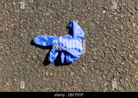 Gesundheitlicher Schutzhandschuh/Handschuhe aus Latex oder Vinyl, die als Abfall auf der Straße entsorgt wurden, vermutlich von einer Person, die sich Sorgen um das Coronavirus COVID-19 macht. Das fallen dieser Handschuhe ist ein neues Phänomen und ist ziemlich weit verbreitet. Twickenham. GROSSBRITANNIEN. Einzelne Handschuhe werden oft einige Meter von ihrem Partner entfernt entsorgt, da der litterer beim fallen der Handschuhe laufen muss. (116) Stockfoto