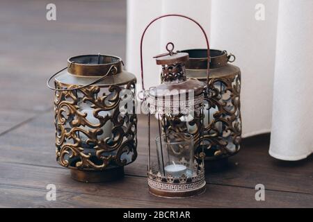 Kerzenhalter aus Kupfer mit weißen Kerzen als Hochzeitsdekoration. Stockfoto