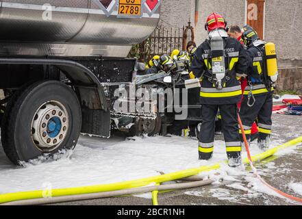 Feuerwehrleute retten eingeklemmten Fahrer während einer Unfallsimulation mit Autos, Zug und Lastwagen. Feuerwehrleute mit Atemschutzgerät und Hyd Stockfoto