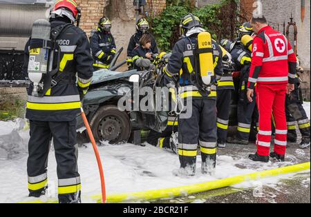 Feuerwehrleute retten eingeklemmten Fahrer während einer Unfallsimulation mit Autos, Zug und Lastwagen. Feuerwehrleute mit Atemschutzgerät und Hyd Stockfoto