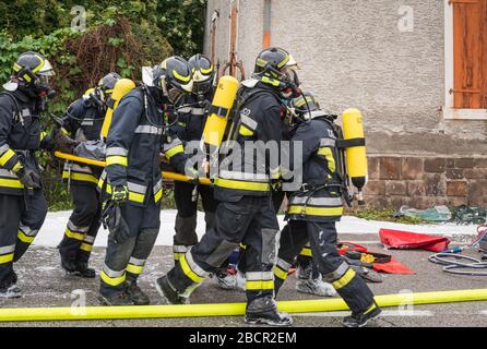 Feuerwehrleute retten eingeklemmten Fahrer während einer Unfallsimulation mit Autos, Zug und Lastwagen. Feuerwehrleute mit Atemschutzgerät und Hyd Stockfoto